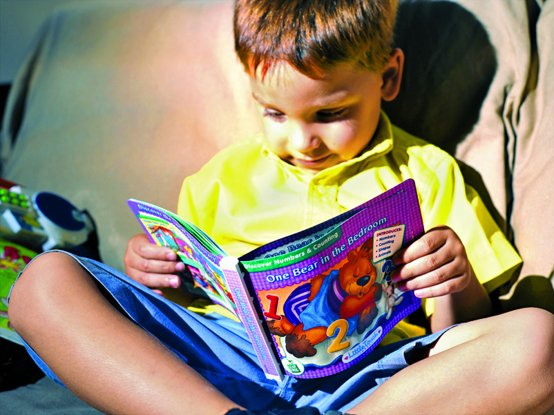 A child reading a book with a reinforced Tyvek cover.